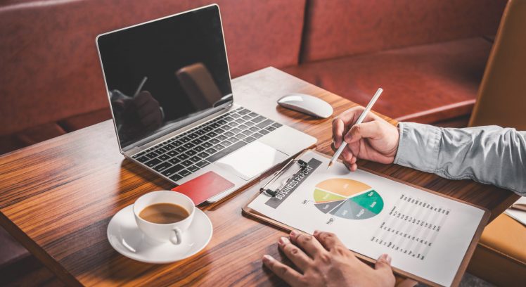 Businessman Hands on a Rustic Wooden Table with laptop Computer a Cup of Coffee. and credit card good photo