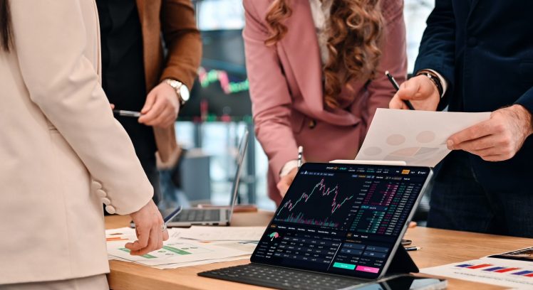 Business meeting in an office, workers discussing business affairs using gadgets and papers with charts