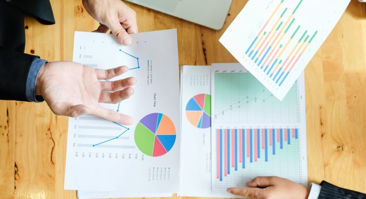 Business team working on a new business plan with modern digital computer. Top view shot.