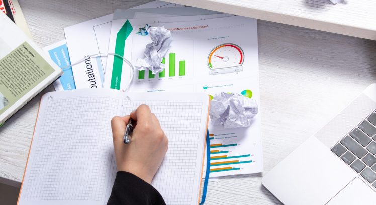 front-view-girl-taking-notes-writing-down-notes-front-table-with-schedules-graphics-laptop-job-business-activity