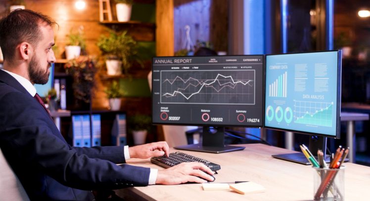 Manager working over the program at the semester report. Works on two monitors